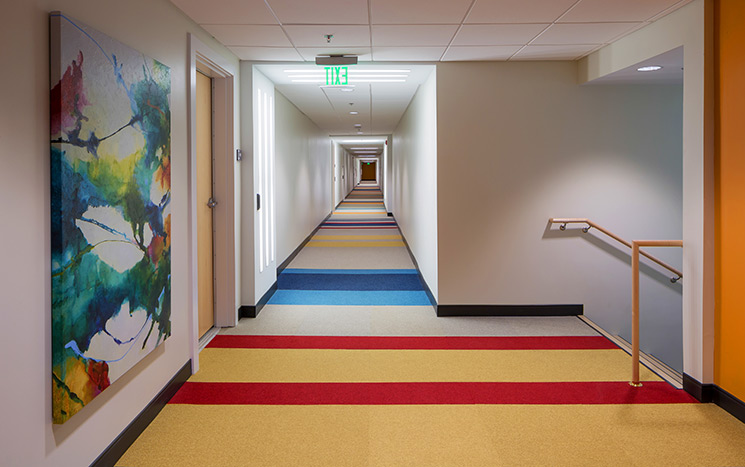 Colorful patterns within the corridors' carpeting provide visual cues for residents with autism.